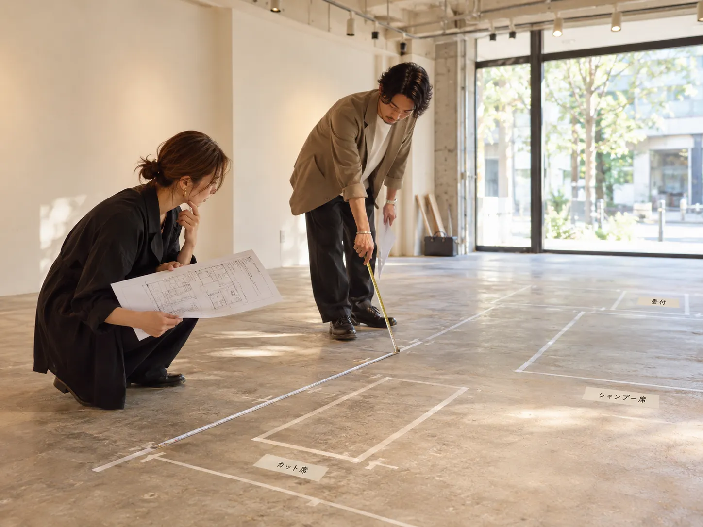 美容室の契約前にテナント内でレイアウト寸法を確認する様子
